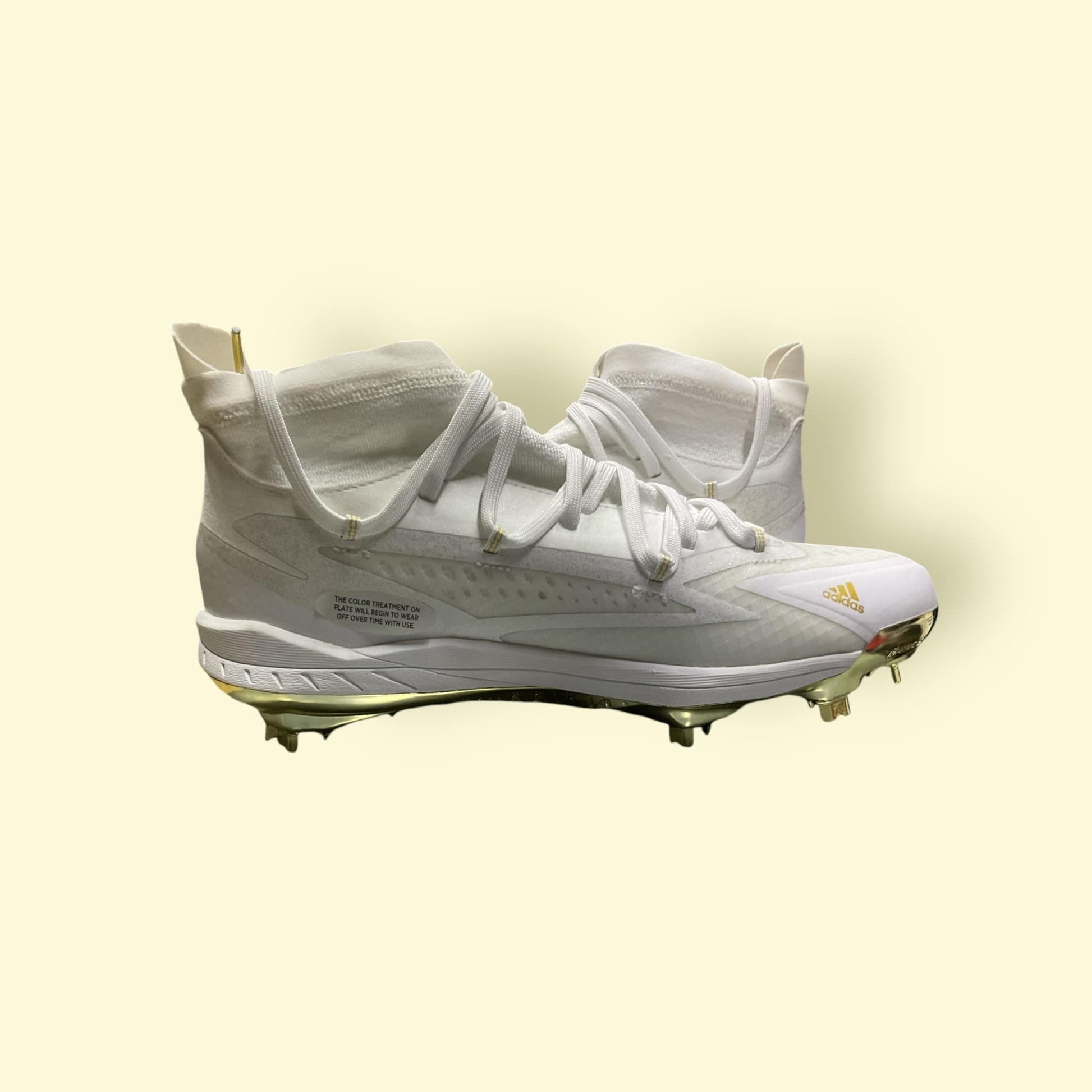 Zapatillas de béisbol Adizero Afterburner 8 NWV en blanco y dorado, ligeras y transpirables, diseñadas para velocidad y tracción óptima en el campo