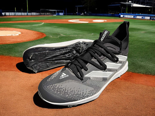 Zapato Adidas Adizero Afterburner 9 NWV gris, diseñado para velocidad, ligereza y tracción en el béisbol.
