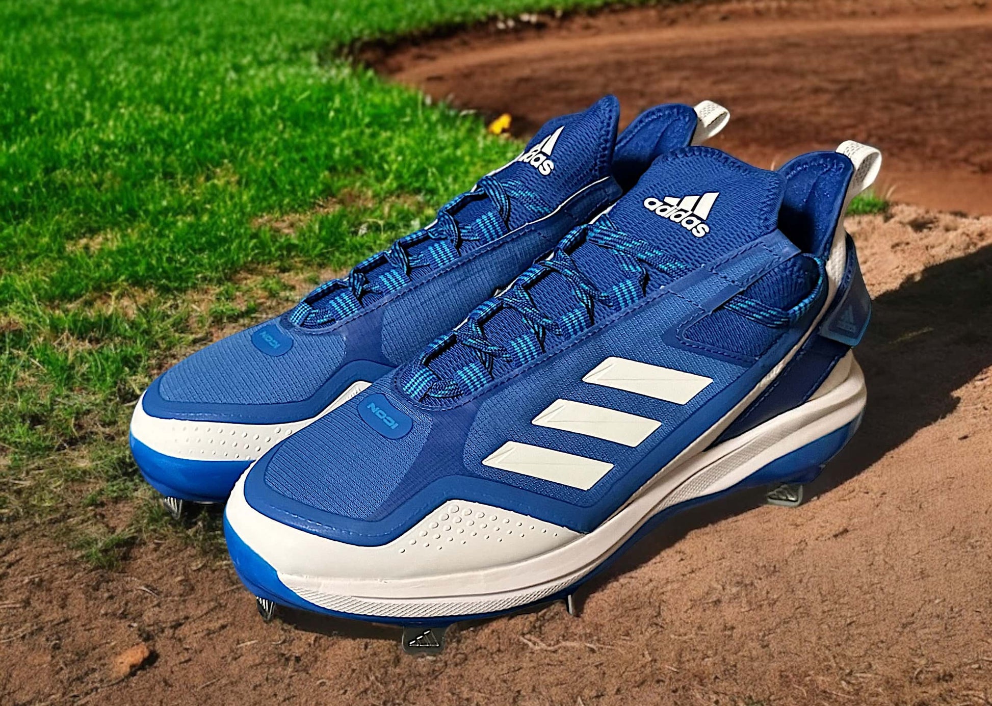 Zapato Adidas Icon 7 Boost Metal en color azul, diseñado para béisbol con tecnología Boost y suela metálica para tracción y rendimiento.