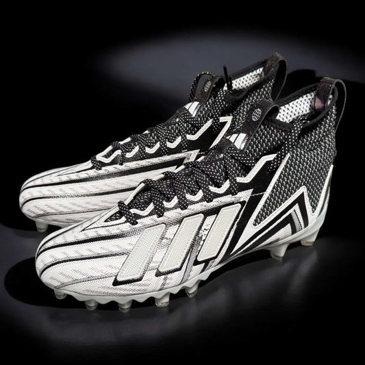 Zapato Adidas Freak In Line blanco y negro, diseñado para rendimiento y tracción óptima en deportes competitivos