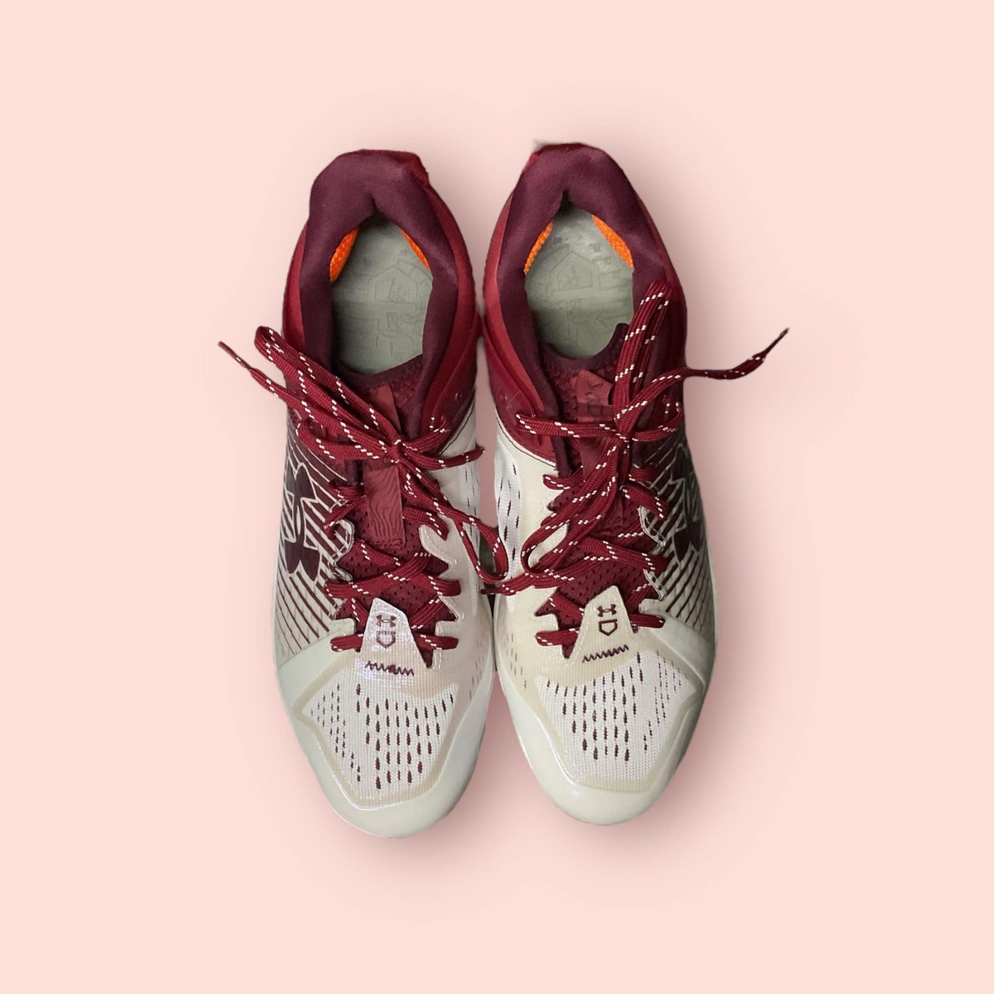 Zapatillas de béisbol UA Yard Low MT en tinto y blanco, con suela de tacos, diseño ligero y bajo, ideales para libertad de movimiento y tracción en el campo