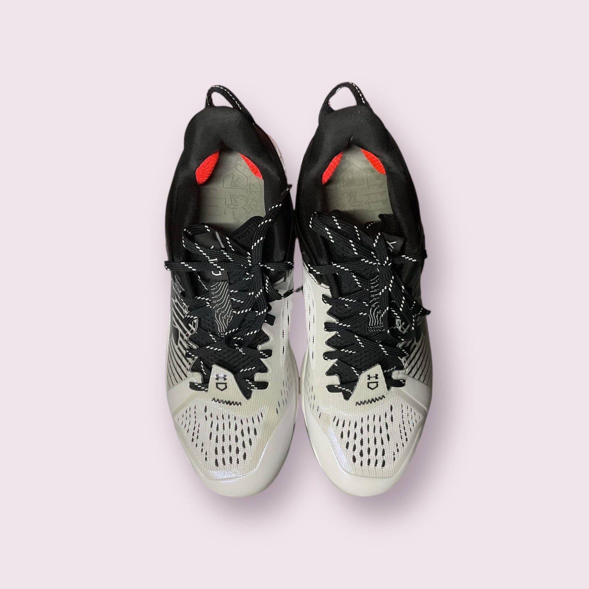 Zapatillas de béisbol UA Yard Low MT en negro y blanco, con suela de tacos, diseño ligero y bajo, ideales para rendimiento y comodidad en el campo