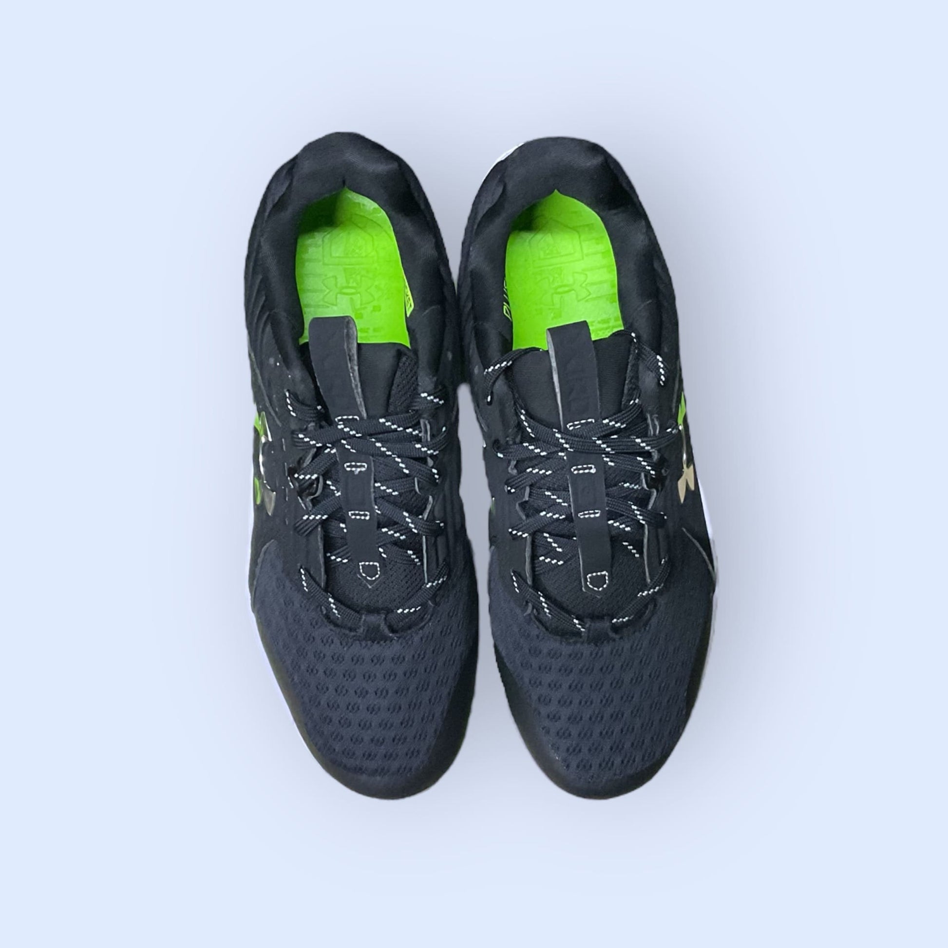 Zapatillas de béisbol UA Yard MT en negro, con suela de tacos y diseño de media altura, diseñadas para ofrecer tracción, comodidad y estabilidad en el campo