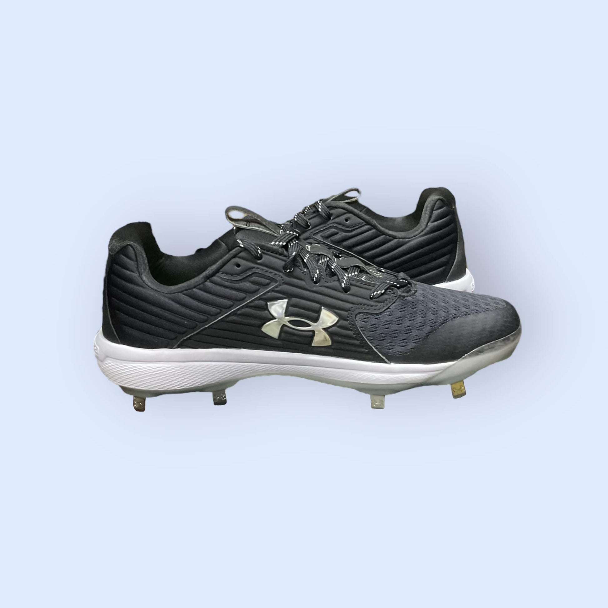 Zapatillas de béisbol UA Yard MT en negro, con suela de tacos y diseño de media altura, diseñadas para ofrecer tracción, comodidad y estabilidad en el campo