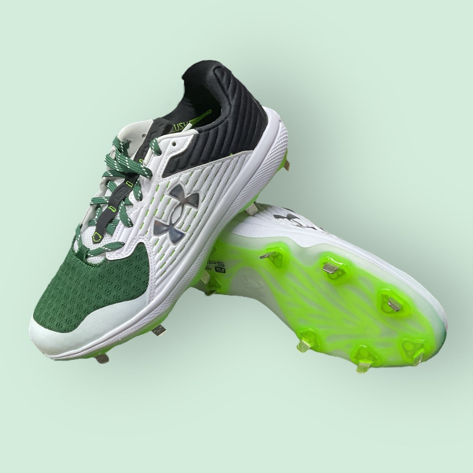 Zapatillas de béisbol UA Yard MT en verde, con suela de tacos y diseño de media altura, ofreciendo estabilidad, comodidad y tracción en el campo