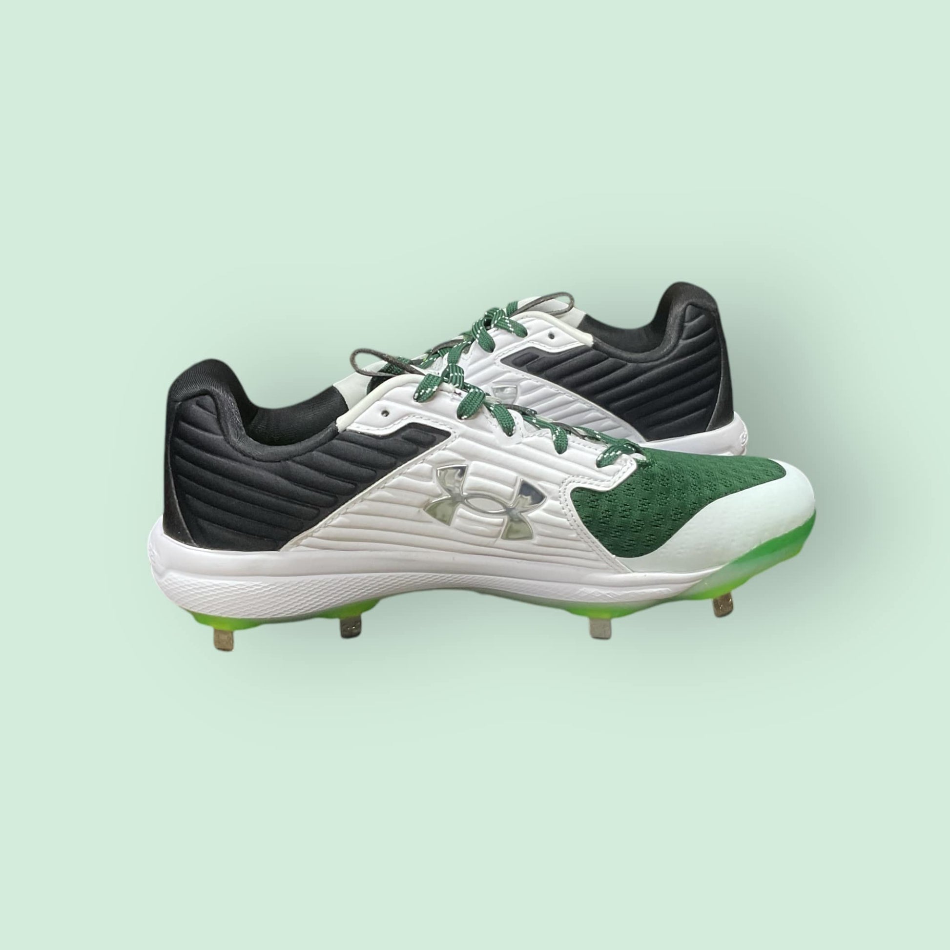 Zapatillas de béisbol UA Yard MT en verde, con suela de tacos y diseño de media altura, ofreciendo estabilidad, comodidad y tracción en el campo