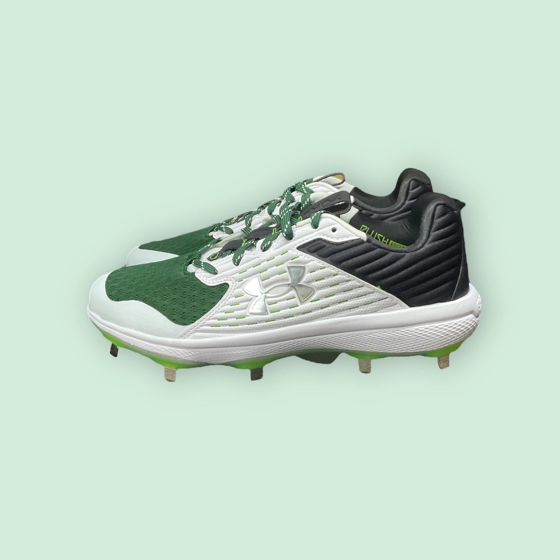 Zapatillas de béisbol UA Yard MT en verde, con suela de tacos y diseño de media altura, ofreciendo estabilidad, comodidad y tracción en el campo