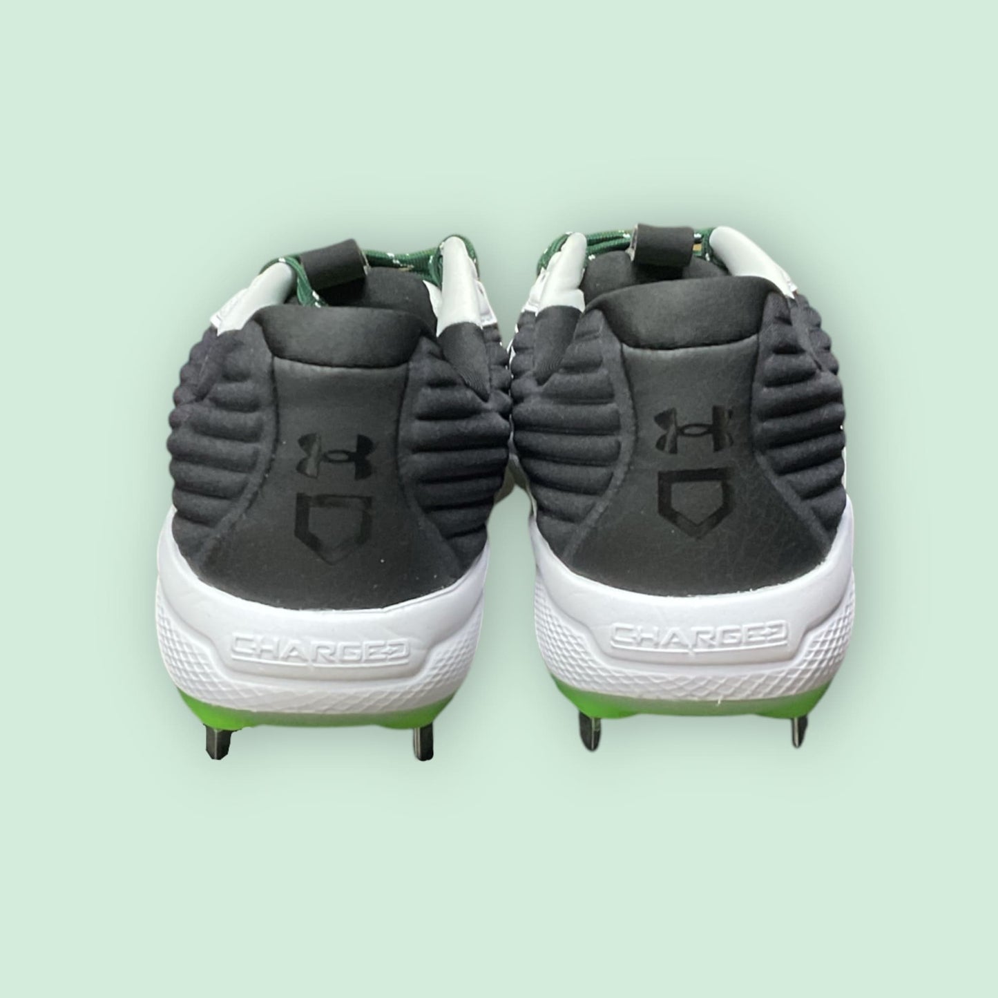 Zapatillas de béisbol UA Yard MT en verde, con suela de tacos y diseño de media altura, ofreciendo estabilidad, comodidad y tracción en el campo