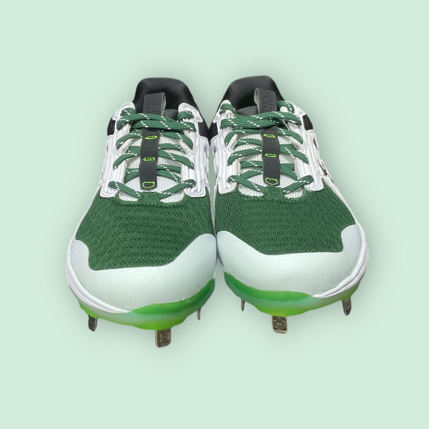 Zapatillas de béisbol UA Yard MT en verde, con suela de tacos y diseño de media altura, ofreciendo estabilidad, comodidad y tracción en el campo
