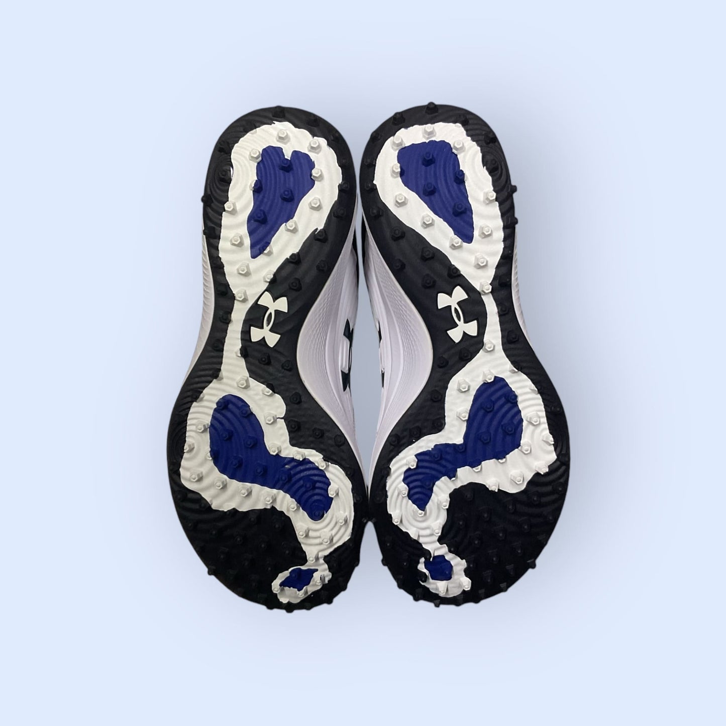 Zapatillas de béisbol UA Yard Turf en blanco y azul, con suela Turf, diseñadas para tracción y comodidad en superficies artificiales durante el entrenamiento