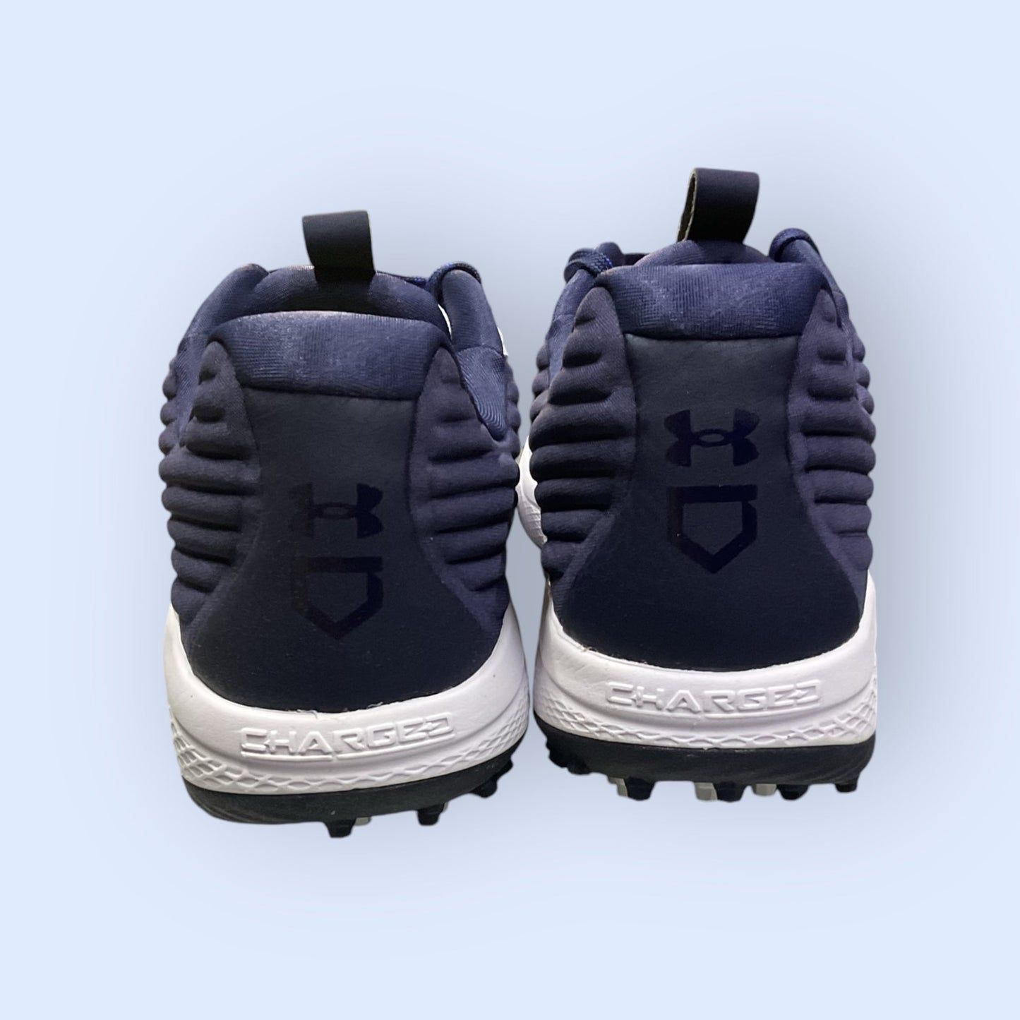Zapatillas de béisbol UA Yard Turf en blanco y azul, con suela Turf, diseñadas para tracción y comodidad en superficies artificiales durante el entrenamiento