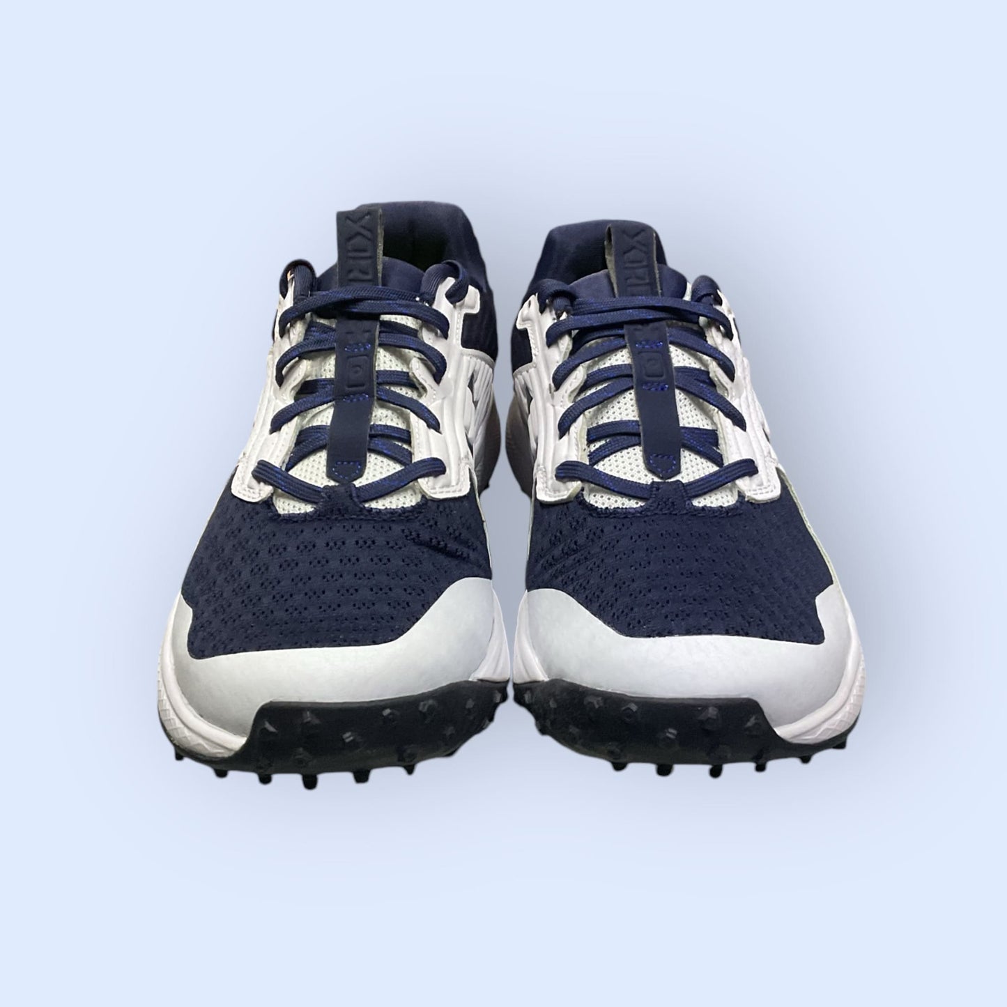 Zapatillas de béisbol UA Yard Turf en blanco y azul, con suela Turf, diseñadas para tracción y comodidad en superficies artificiales durante el entrenamiento