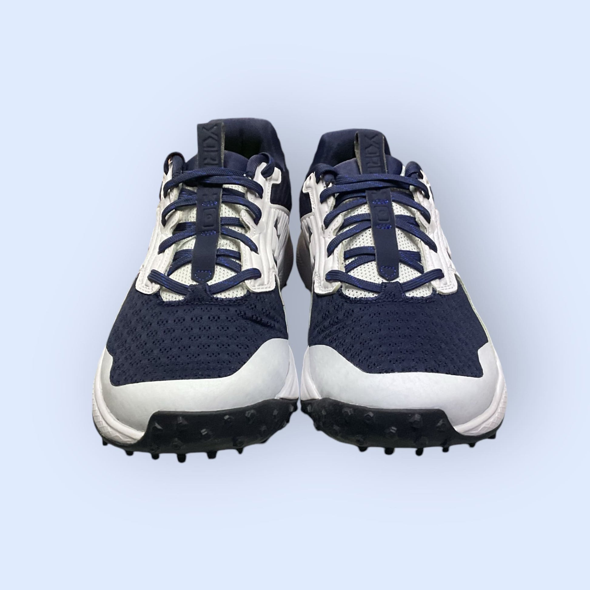 Zapatillas de béisbol UA Yard Turf en blanco y azul, con suela Turf, diseñadas para tracción y comodidad en superficies artificiales durante el entrenamiento