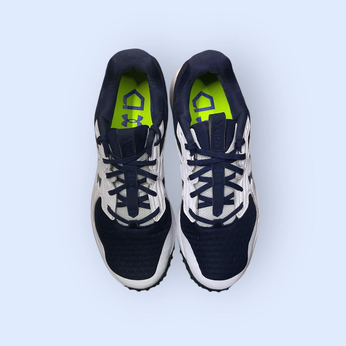 Zapatillas de béisbol UA Yard Turf en blanco y azul, con suela Turf, diseñadas para tracción y comodidad en superficies artificiales durante el entrenamiento