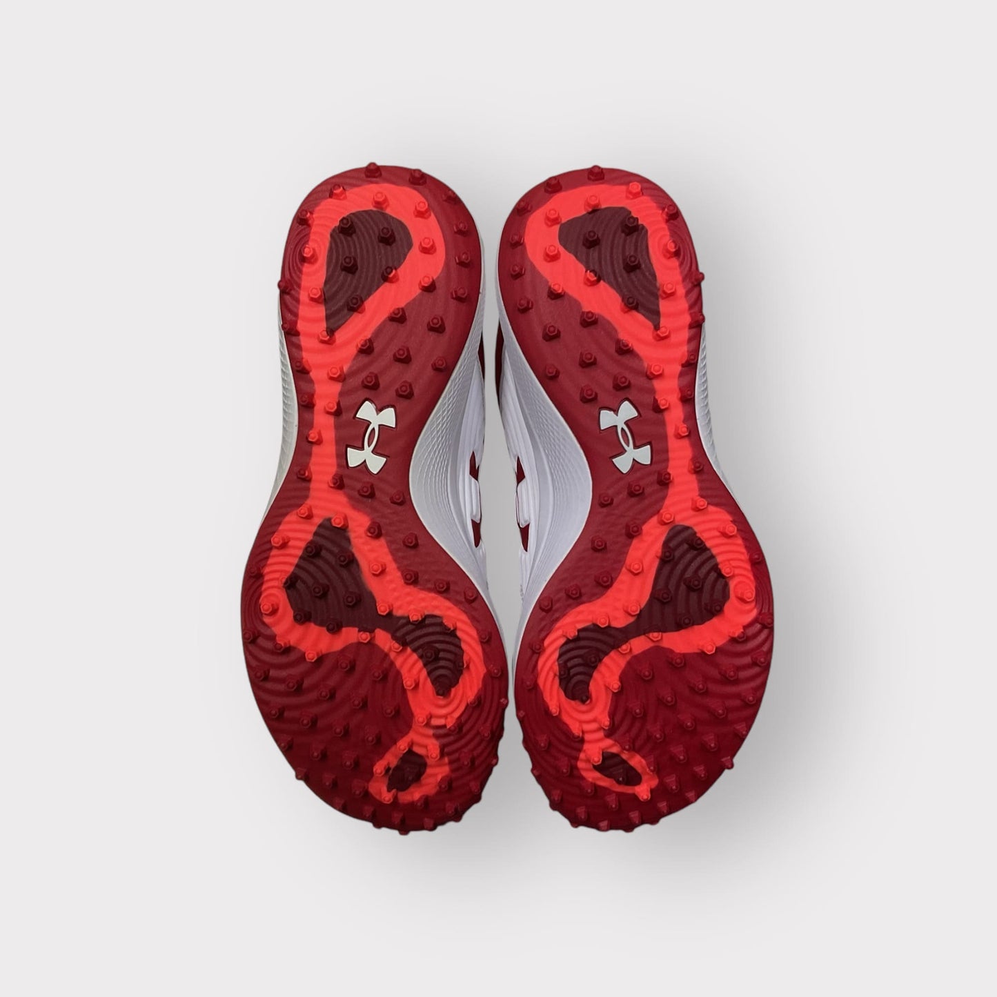 Zapatillas de béisbol UA Yard Turf en blanco y rojo, con suela Turf, diseñadas para entrenamiento con gran tracción y comodidad en superficies artificiales