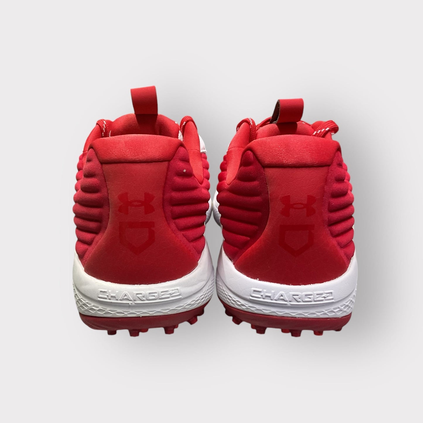 Zapatillas de béisbol UA Yard Turf en blanco y rojo, con suela Turf, diseñadas para entrenamiento con gran tracción y comodidad en superficies artificiales
