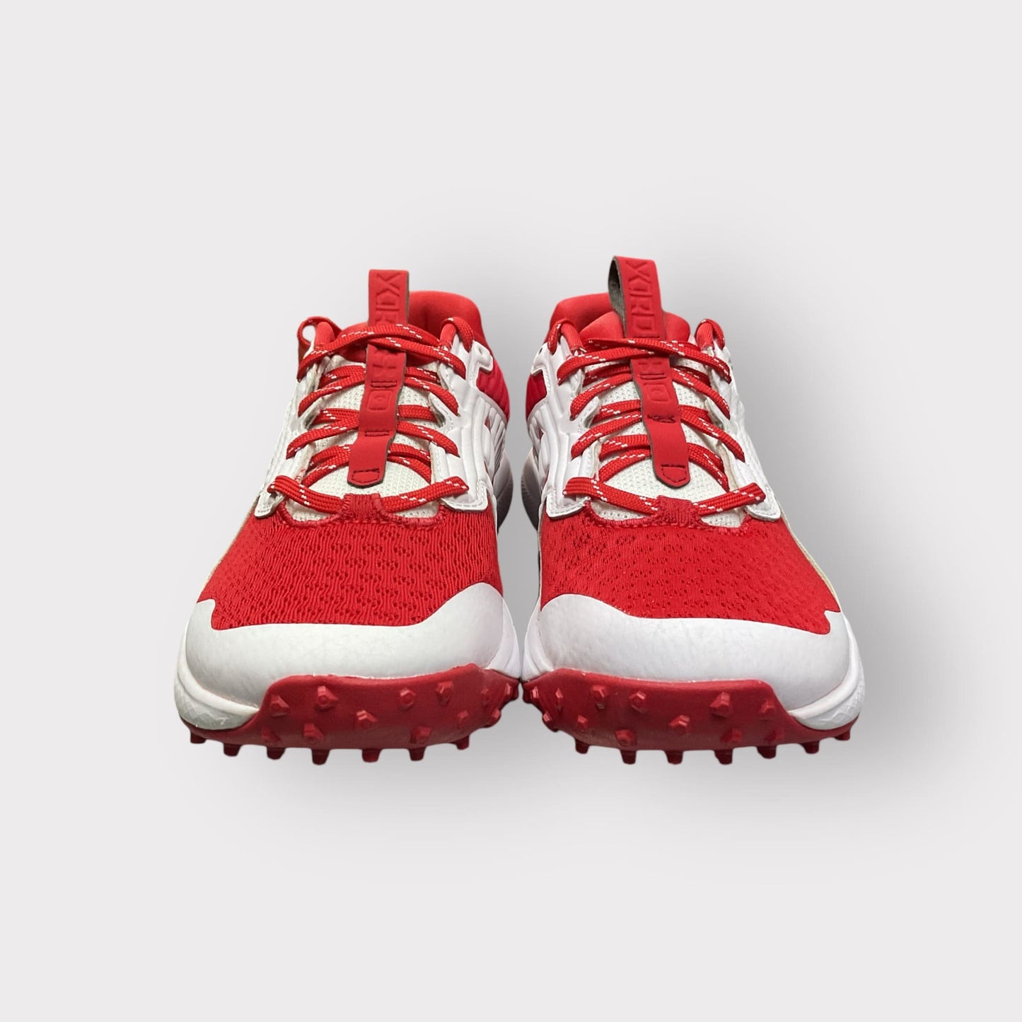 Zapatillas de béisbol UA Yard Turf en blanco y rojo, con suela Turf, diseñadas para entrenamiento con gran tracción y comodidad en superficies artificiales