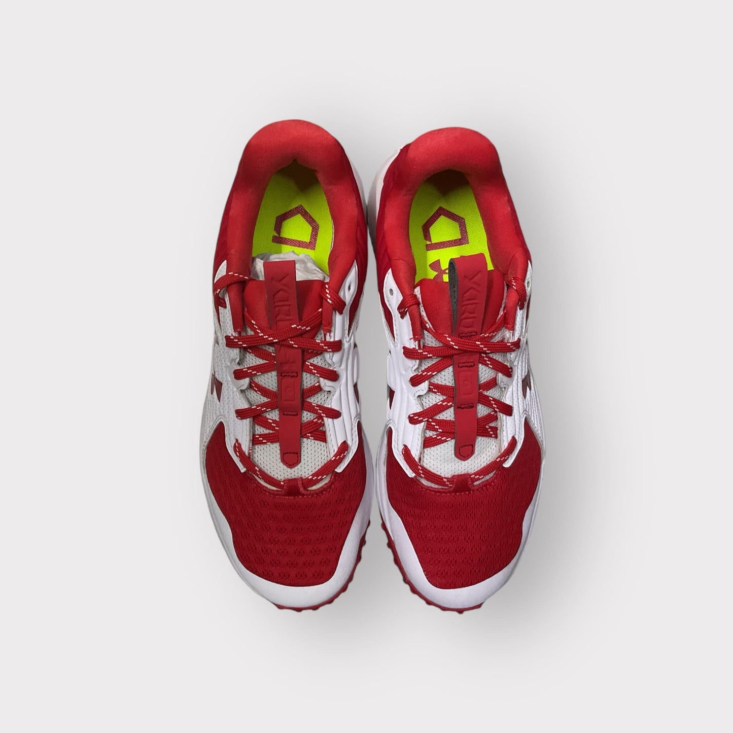 Zapatillas de béisbol UA Yard Turf en blanco y rojo, con suela Turf, diseñadas para entrenamiento con gran tracción y comodidad en superficies artificiales