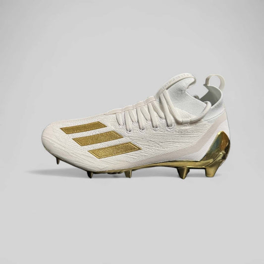 Zapato Adidas Adizero Primeknit blanco y dorado, diseñado para béisbol con tejido flexible y suela metálica para tracción superior.