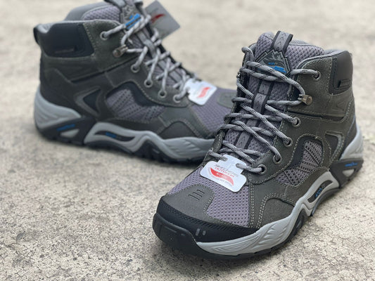 Botas Skechers Percival negras y grises, con suela antideslizante y diseño cómodo y versátil para actividades al aire libre y uso diario