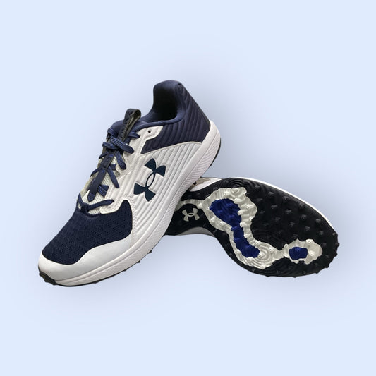 Zapatillas de béisbol UA Yard Turf en blanco y azul, con suela Turf, diseñadas para tracción y comodidad en superficies artificiales durante el entrenamiento