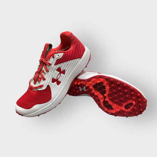 Zapatillas de béisbol UA Yard Turf en blanco y rojo, con suela Turf, diseñadas para entrenamiento con gran tracción y comodidad en superficies artificiales
